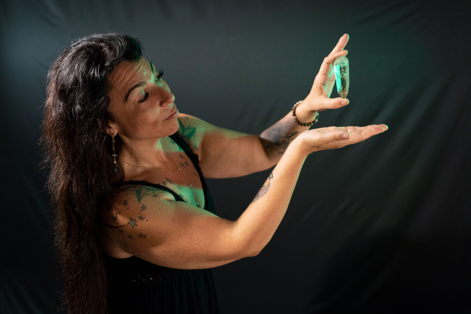 Lightworker Audrey Love holds a quartz crystal, shrouded in green light
